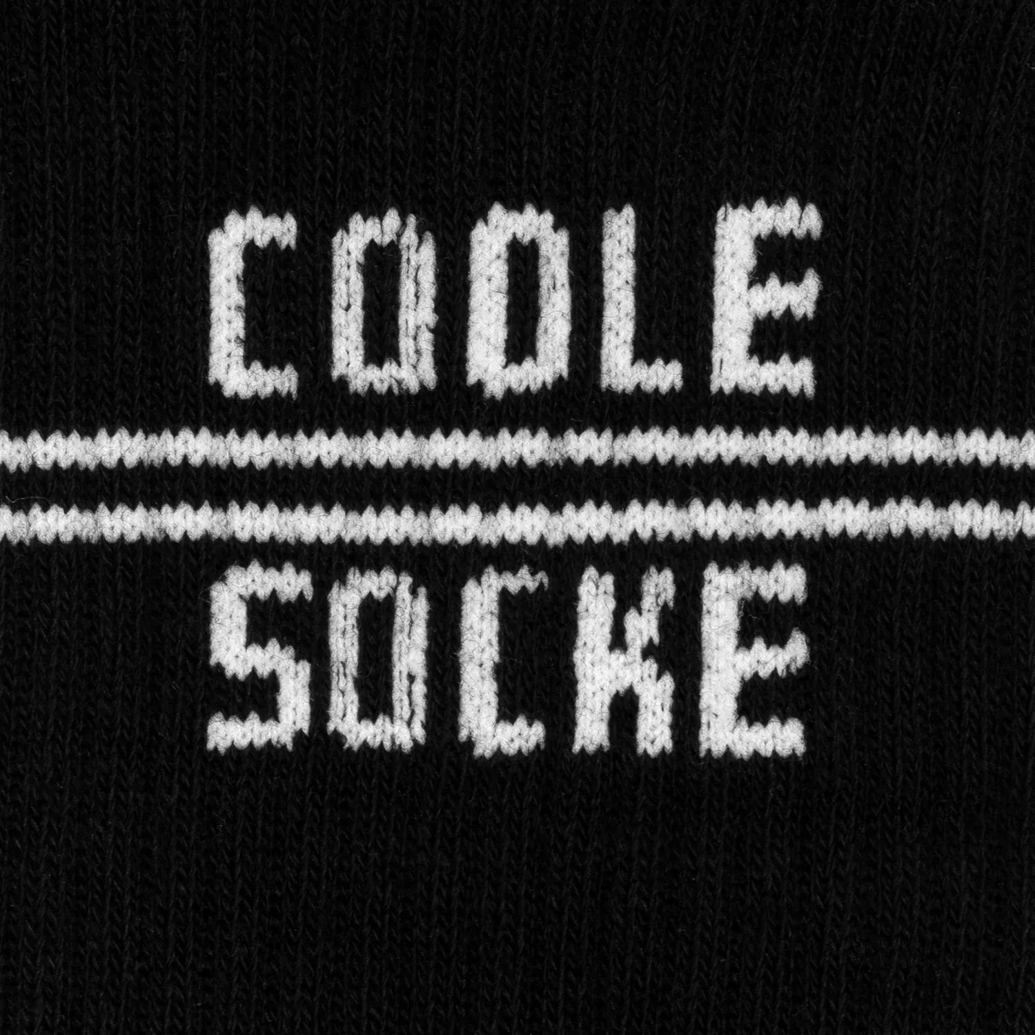 Schwarze Socke mit weißem Schriftzug 'COOLE SOCKE' auf gestricktem Material