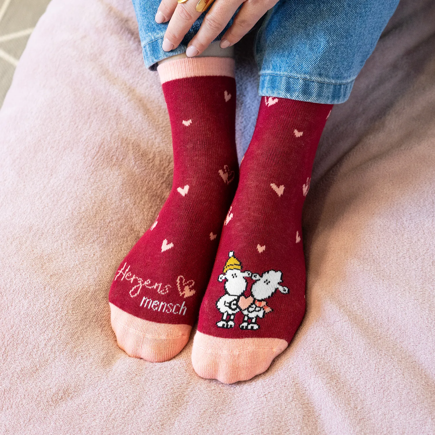 Rote Zaubersocken mit Herzmotiven und niedlichem Comic-Pärchen am Fuß