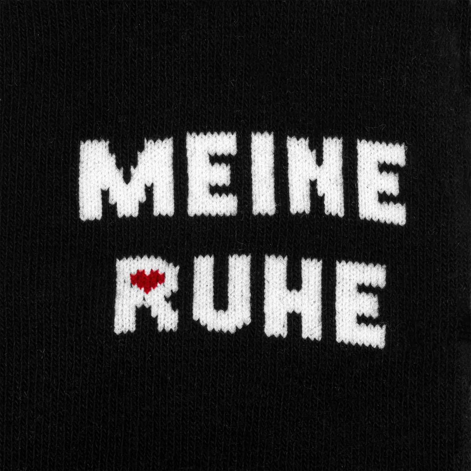 Schwarze Zaubersocken mit weißem MEINE RUHE-Schriftzug und kleinem rotem Herz.