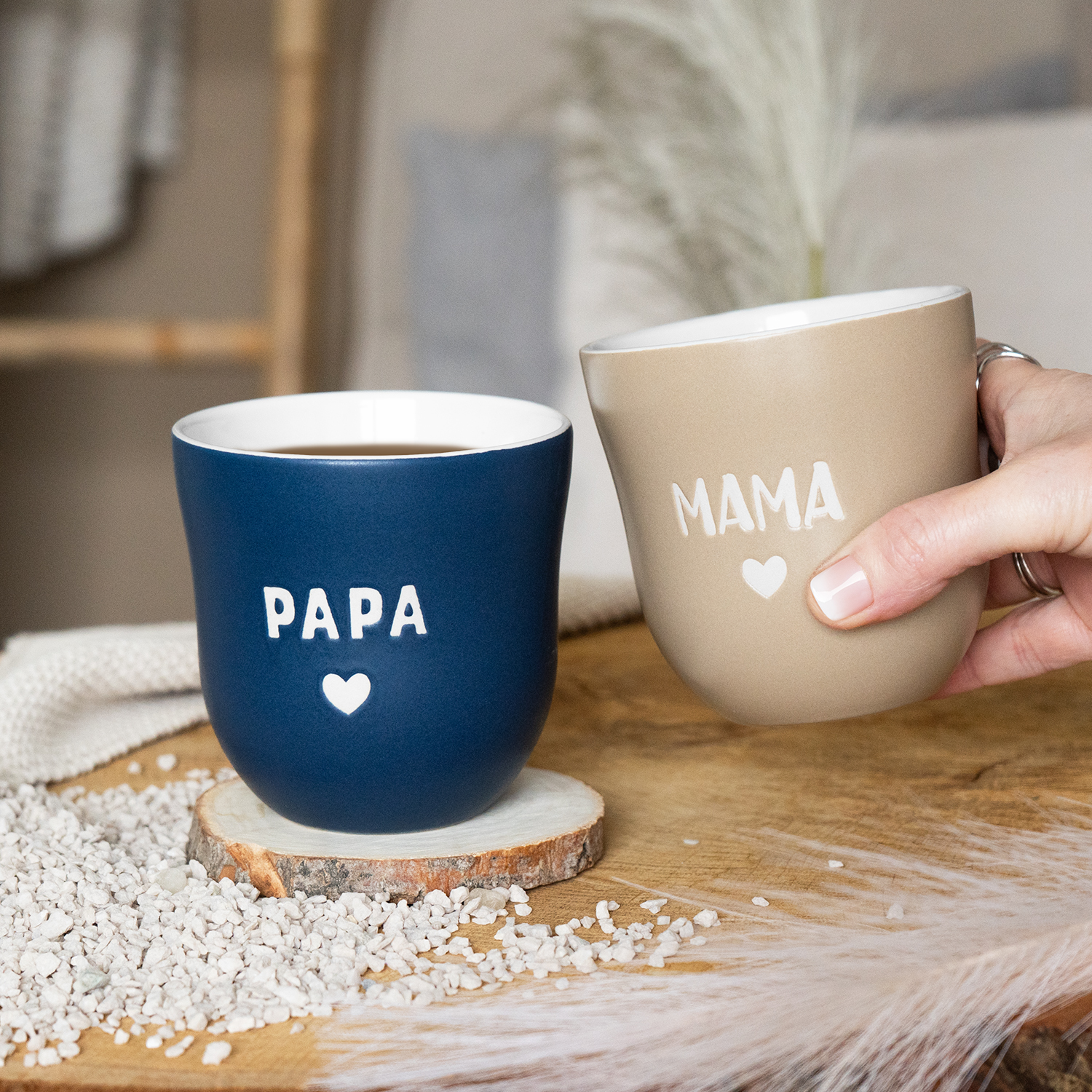 Zwei matte Steinzeug-Becher mit PAPA- und MAMA-Schriftzug und Herz in Blau/Beige