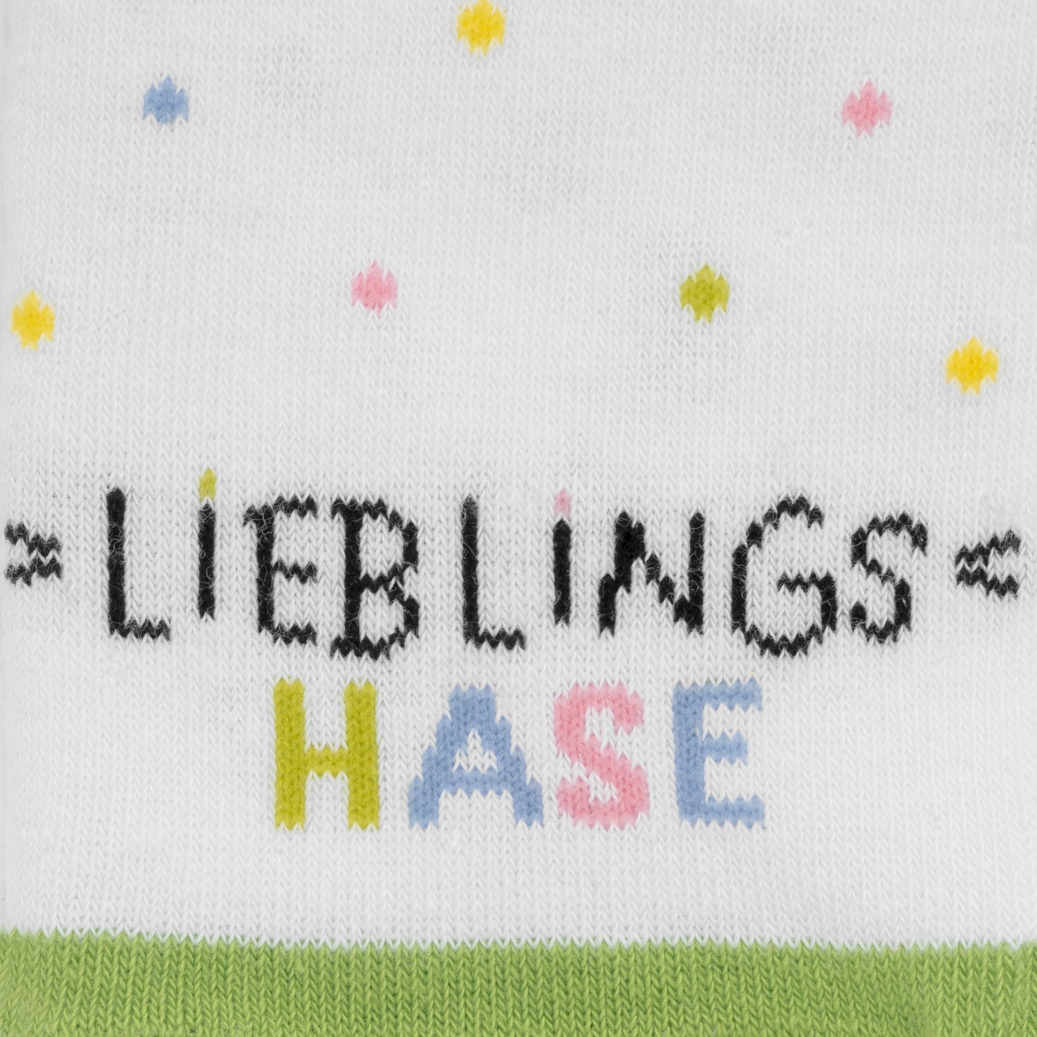 Weiße Zaubersocken mit buntem Schriftzug LIEBLINGS HASEN und Pastellpunkten.
