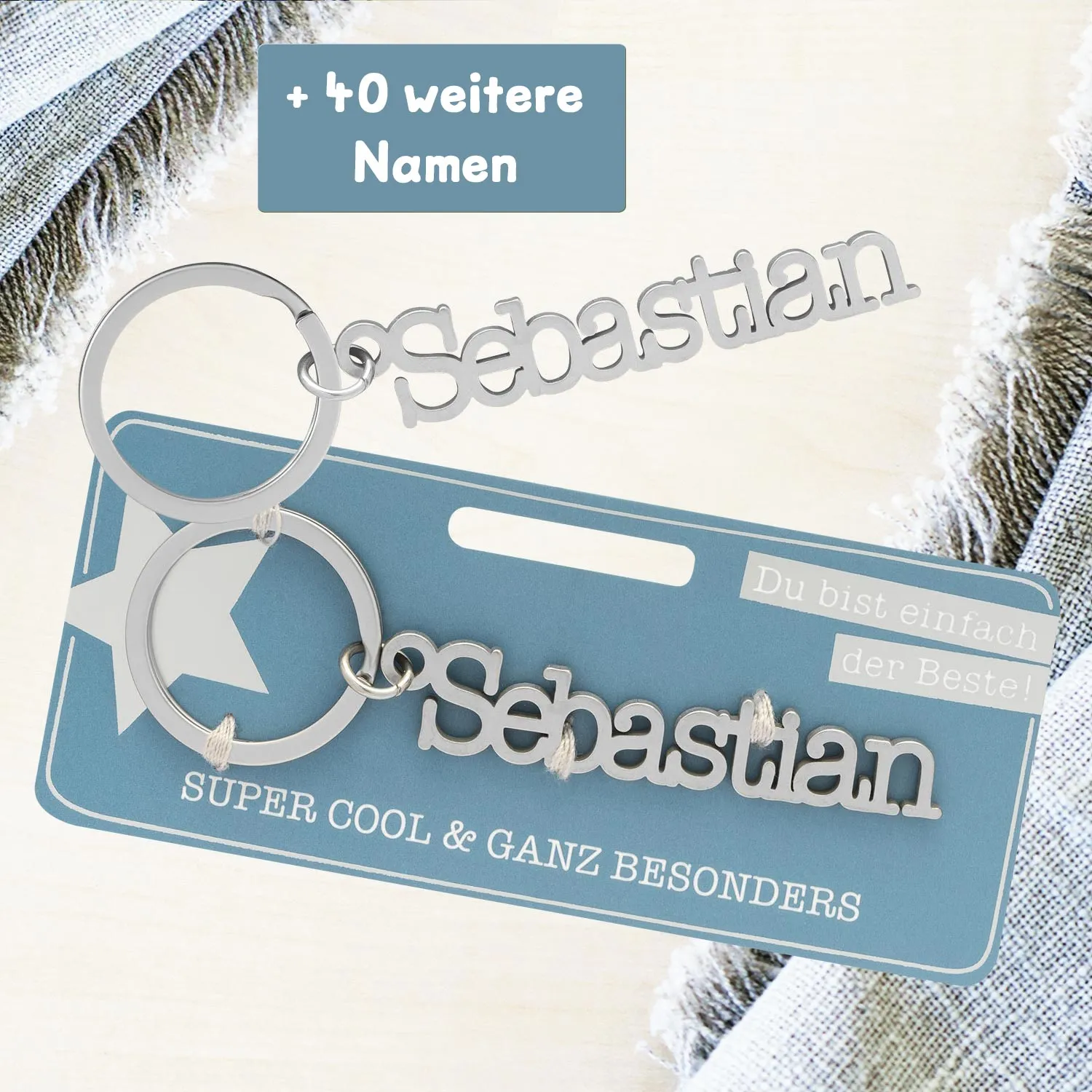 Schlüsselanhänger mit Namenszug Sebastian aus Edelstahl, vor blauer Verpackung
