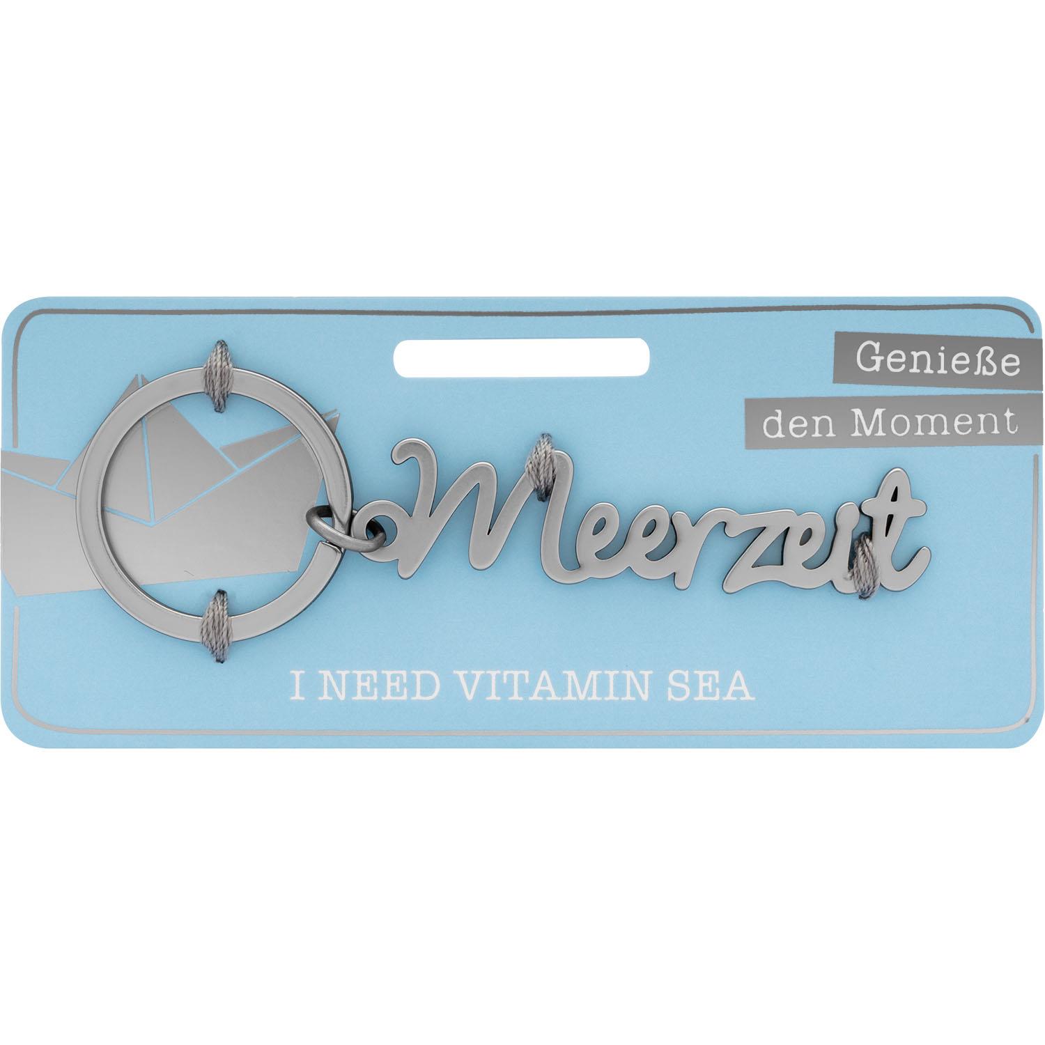 Schlüsselanhänger Meerzeit aus Edelstahl, silberner Schriftzug am Ring, auf heller blauer Kartenverpackung