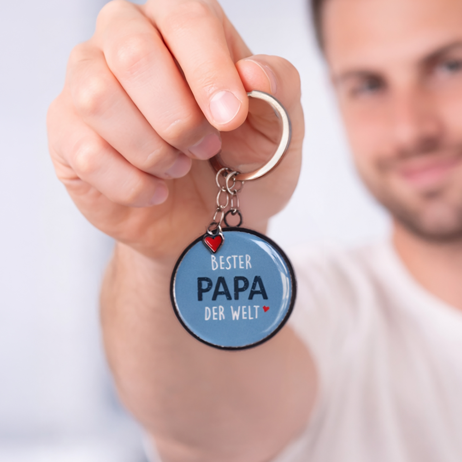 Runder blauer Schlüsselanhänger mit Schriftzug 'BESTER PAPA DER WELT' und kleinem roten Herz