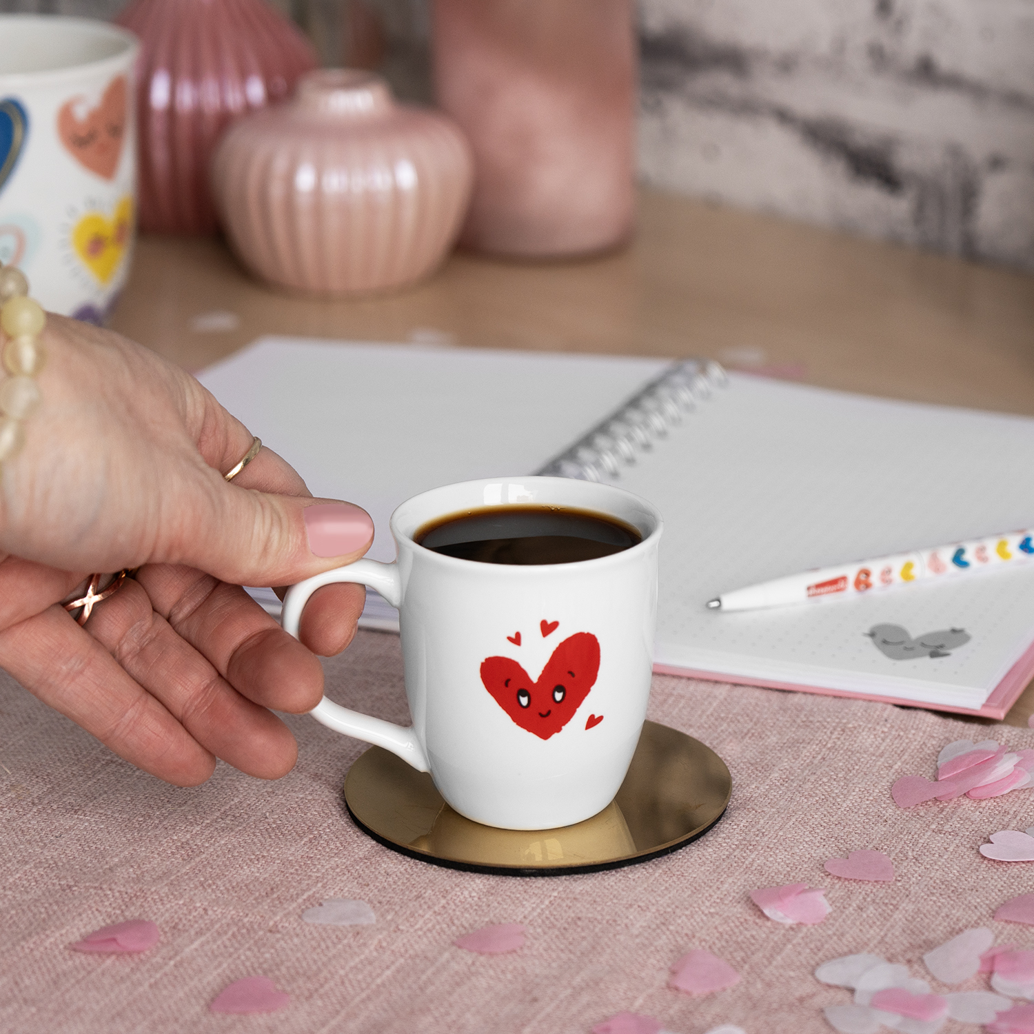 Weiße Espressotasse mit rotem Herz-Motiv.