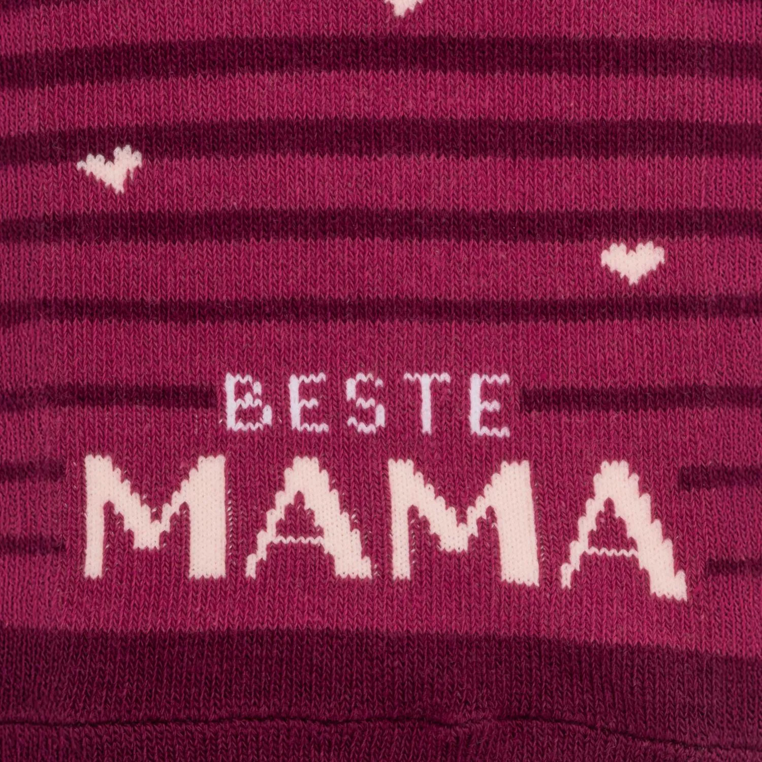 Rosa gestrickte Socke mit Aufdruck 'Beste Mama' und Herzchen.