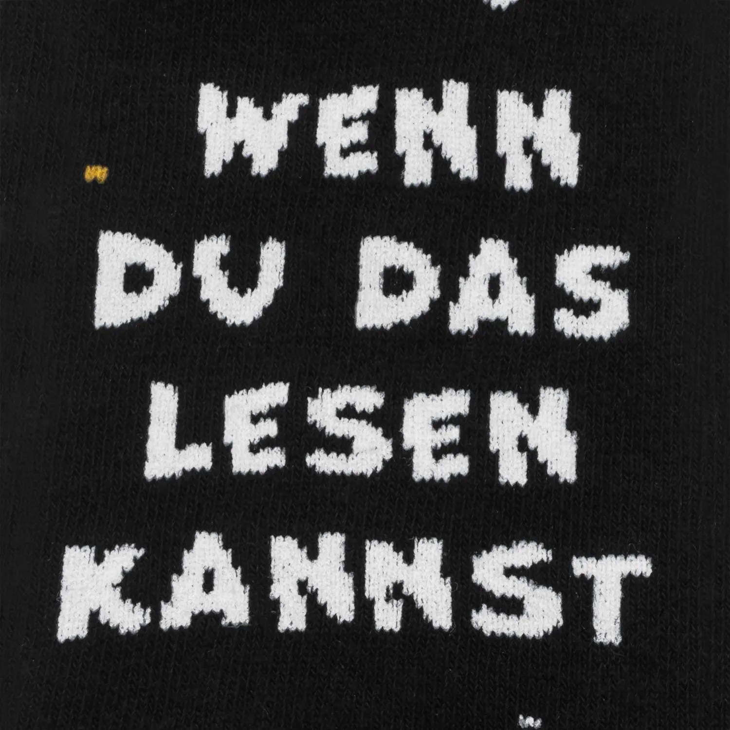 Schwarze Socke mit weißem, blockigem Schriftzug 'WENN DU DAS LESEN KANNST'.