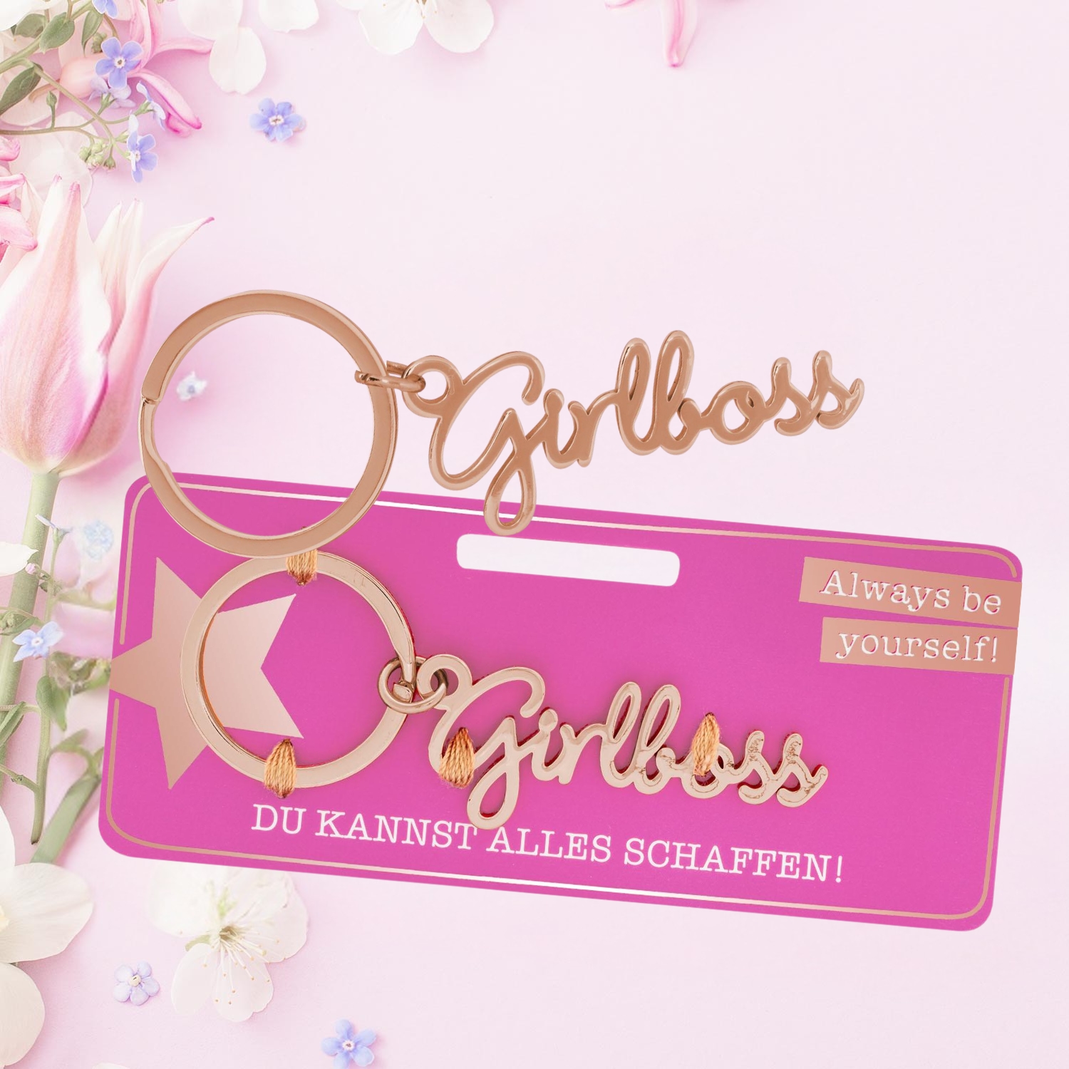 Roségoldener Schlüsselanhänger mit Schriftzug 'Girlboss' an rosa Headerkarte