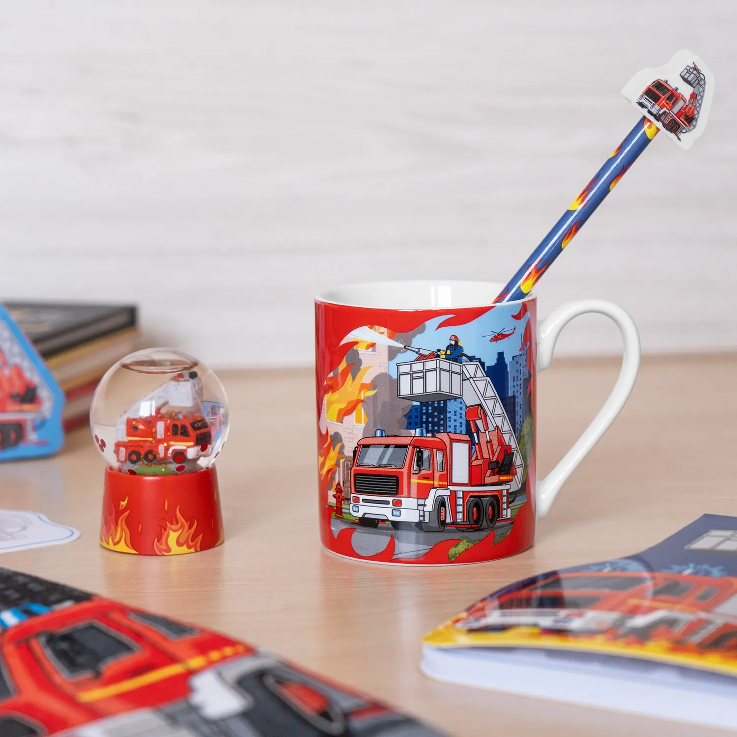 Rote Porzellantasse mit Feuerwehr-Löschfahrzeug-Motiv und blauem Strohhalm