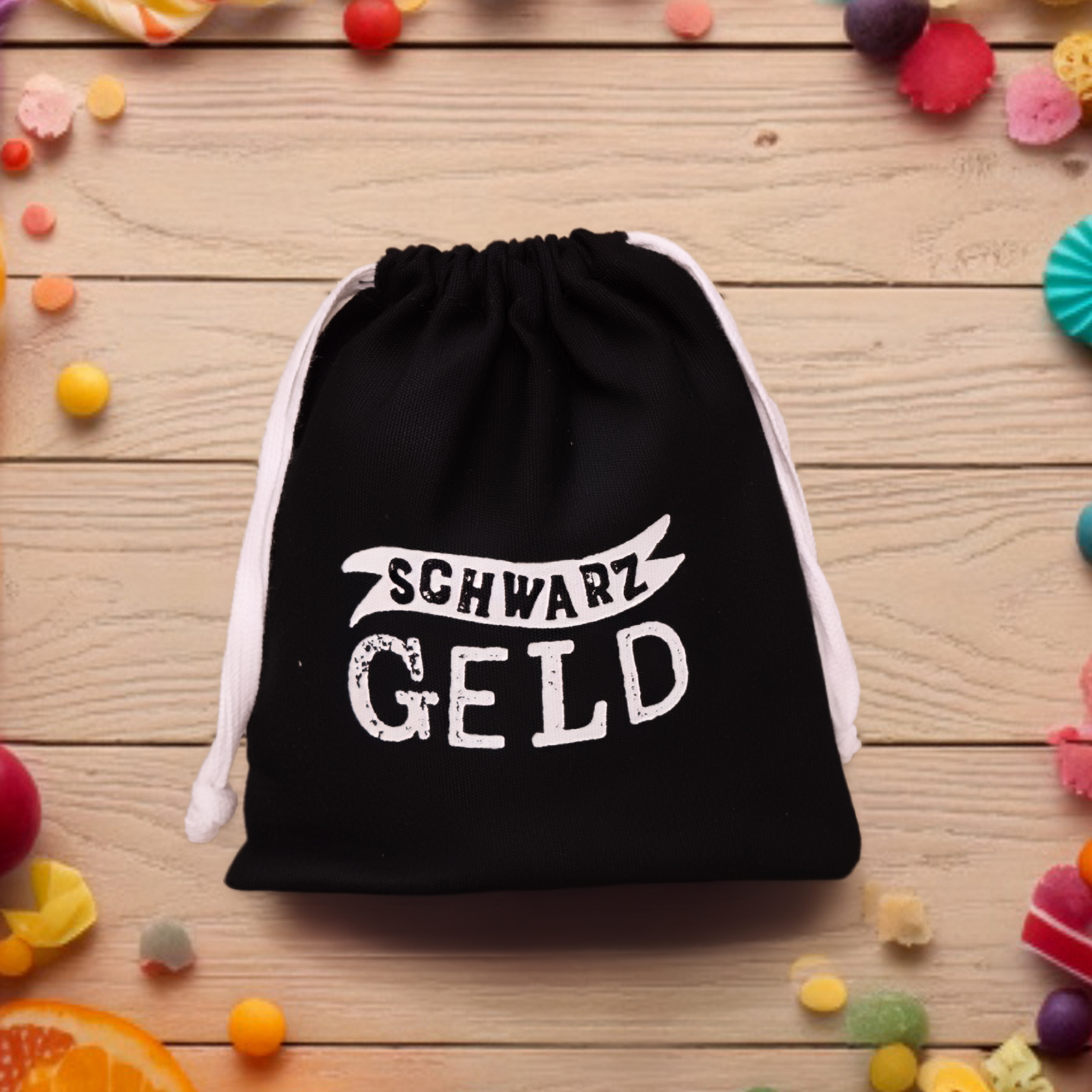 Schwarzes Geschenksäckchen mit Weißdruck 'SCHWARZ GELD' vor Holztisch.