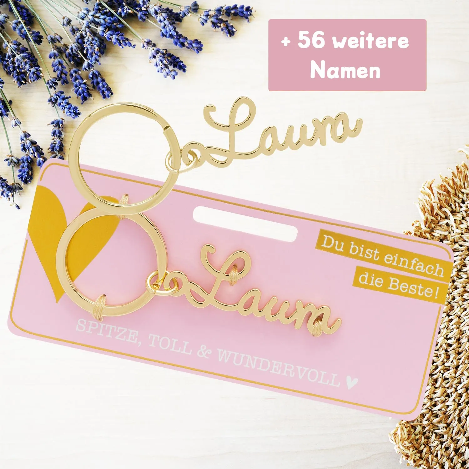 Goldfarbener Namensschriftzug Laura als Schlüsselanhänger auf rosa Karte.