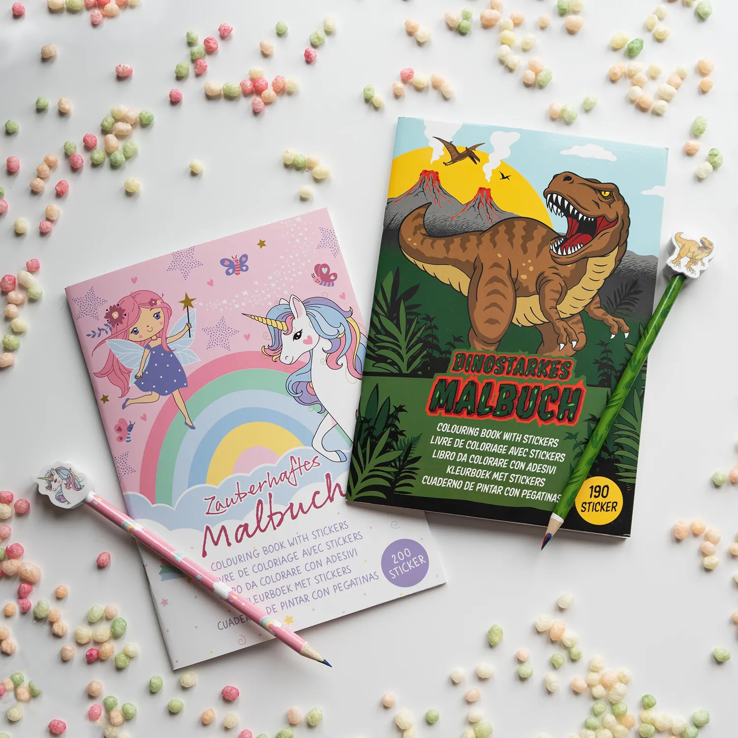 Zwei Malbücher mit Dino- und Einhorn-Motiven, Stickerbogen und Buntstiften für Kinder.