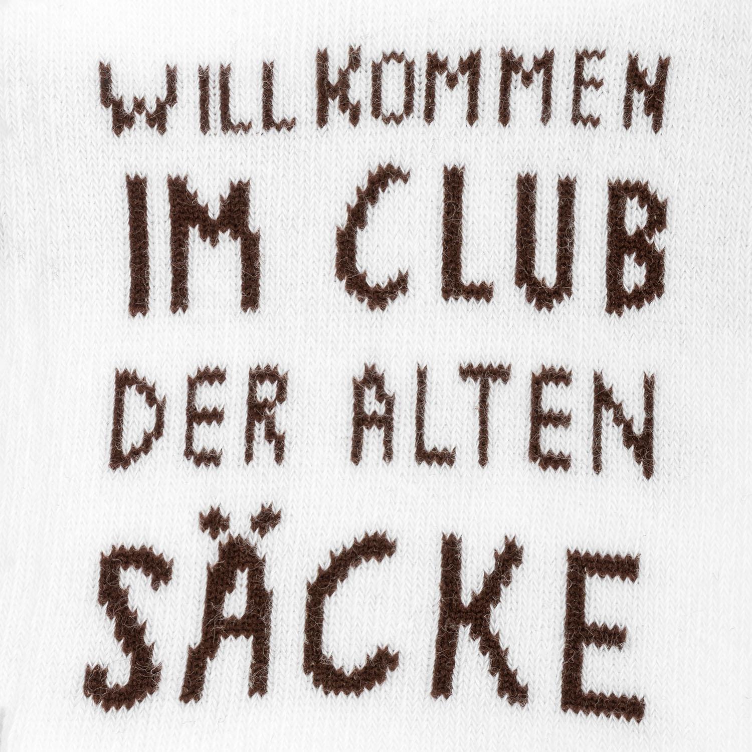 Weiße Socke mit braunem Text 'WILLKOMMEN IM CLUB DER ALTEN SÄCKE'