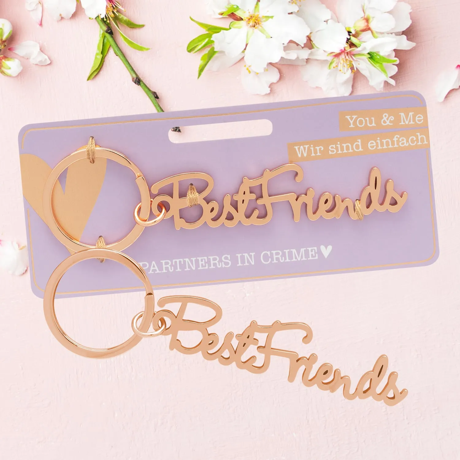 Roségoldener Schlüsselanhänger mit Schriftzug 'Best Friends' und zwei Ringen auf lavendelverpackung