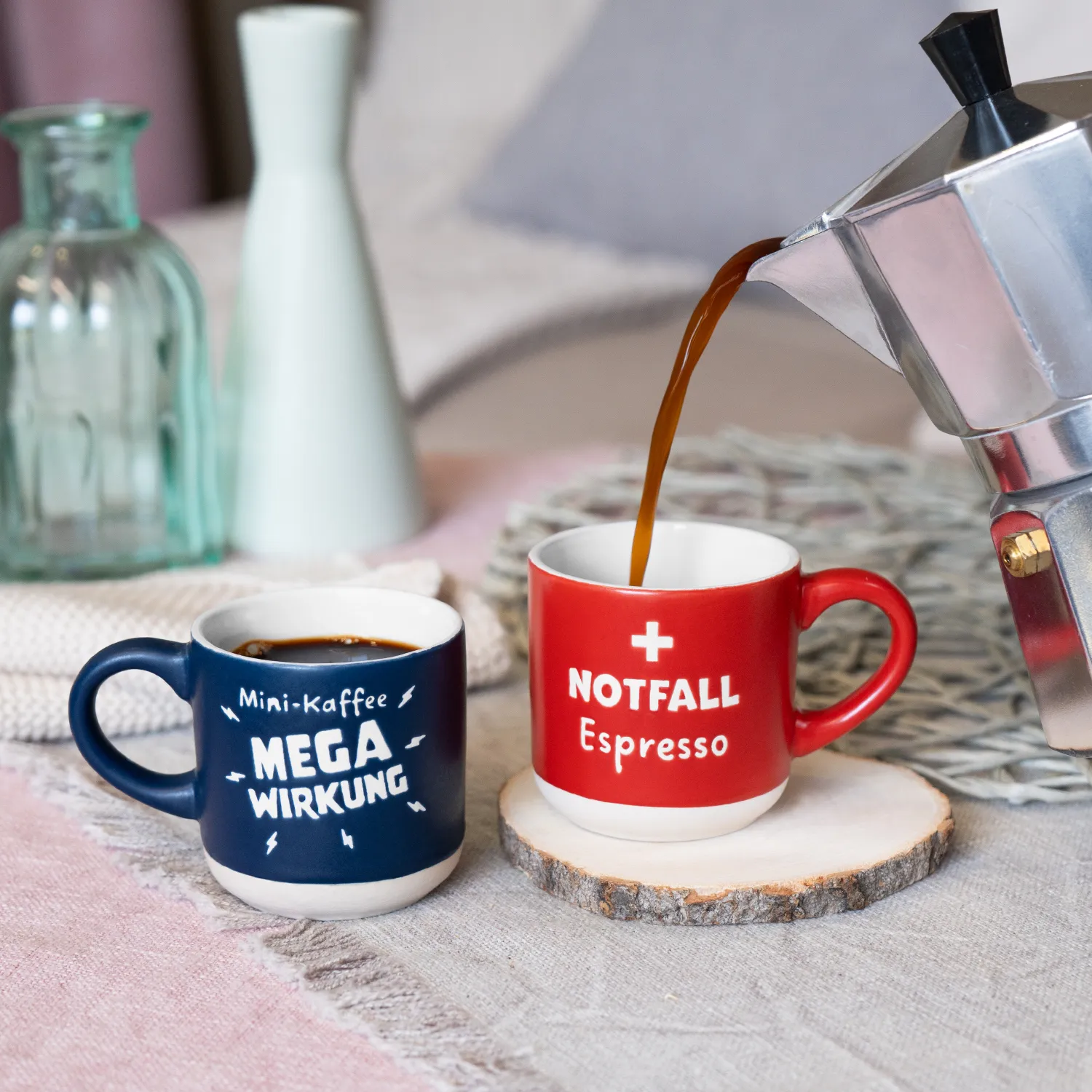 Rote Notfall-Espressotasse mit Innenraum, daneben blaue Mega-Wirkung-Tasse