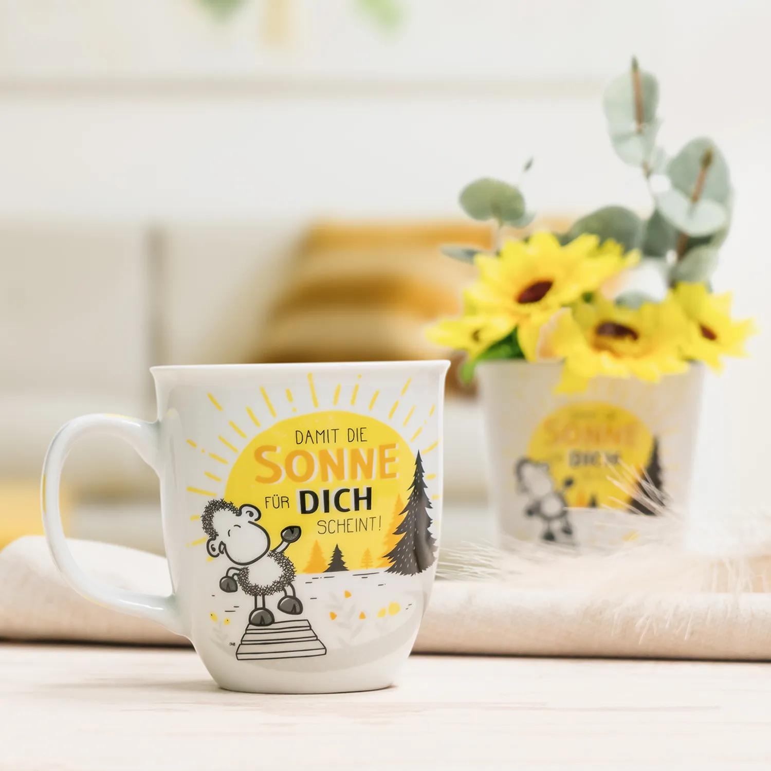 Weiße Porzellan-Tasse »Damit die Sonne für Dich scheint!« mit gelber Sonne und Schaf-Dessin.