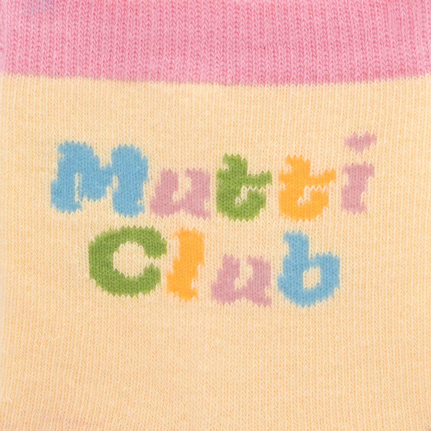 Zaubersocken Mutti Club in Pastellfarben mit buntem Schriftzug auf gelbem Hintergrund