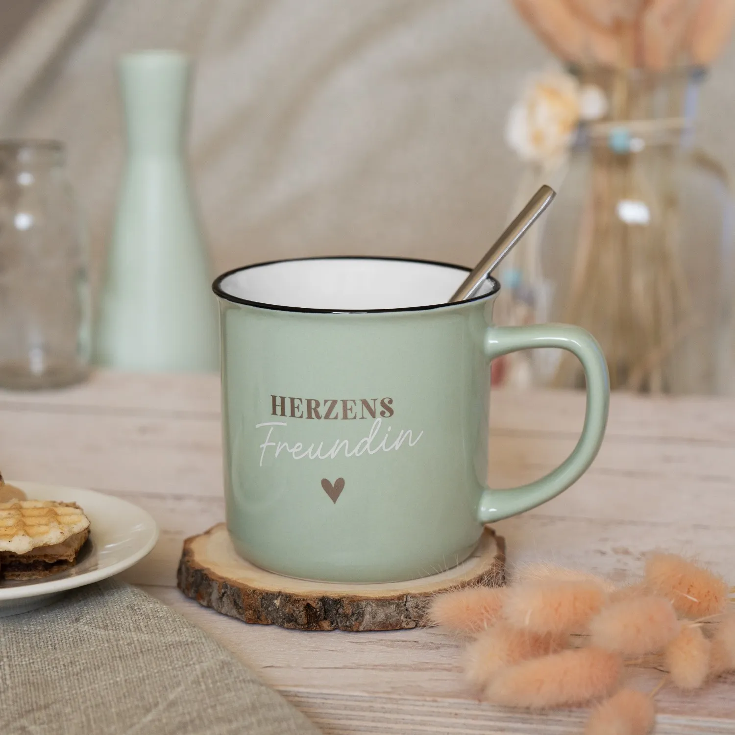 Mintgrüner Becher mit weißem Innenraum und Aufdruck 'Herzens Freundin' samt kleinem Herz