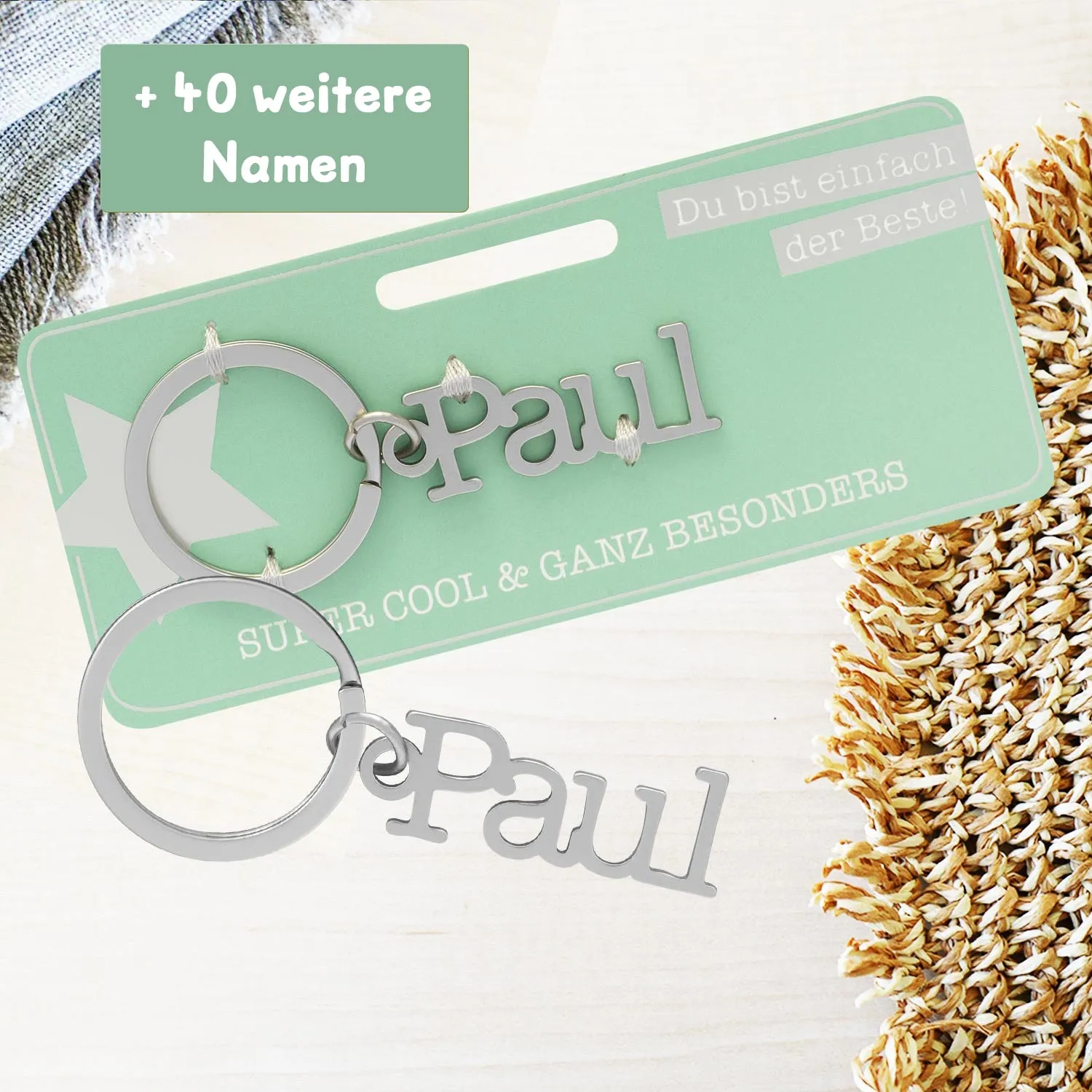 Personalisierter Namens-Schlüsselanhänger aus Metall mit dem Namen Paul an einer mintgrünen Headerkarte.