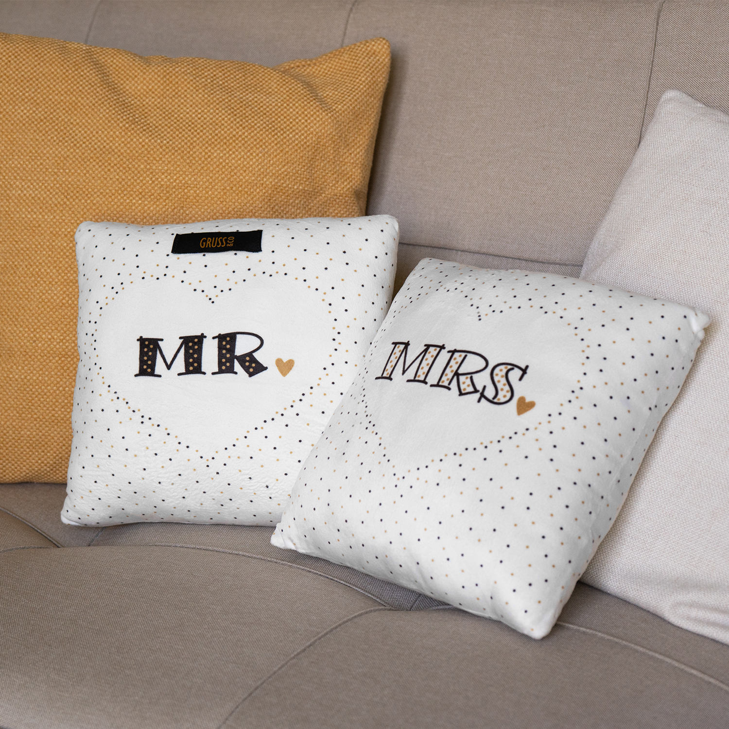 Weiße Plüschkissen mit MR/MRS-Schriftzug und Herzmotiven; Punktedesign in Schwarz und Gold